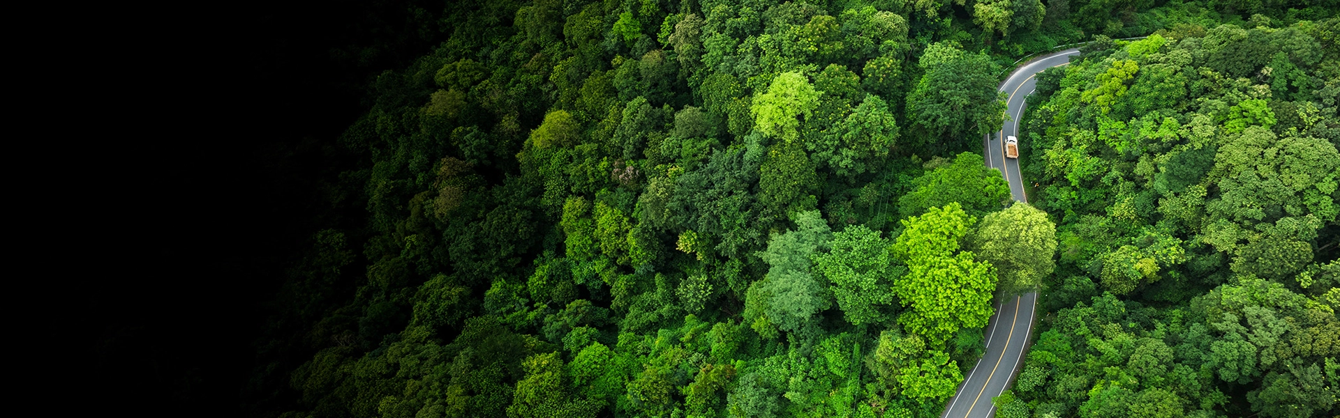 Aerial view of a truck on a forest road, symbolizing the benefits of the GHG Calculator for carbon footprint tracking.