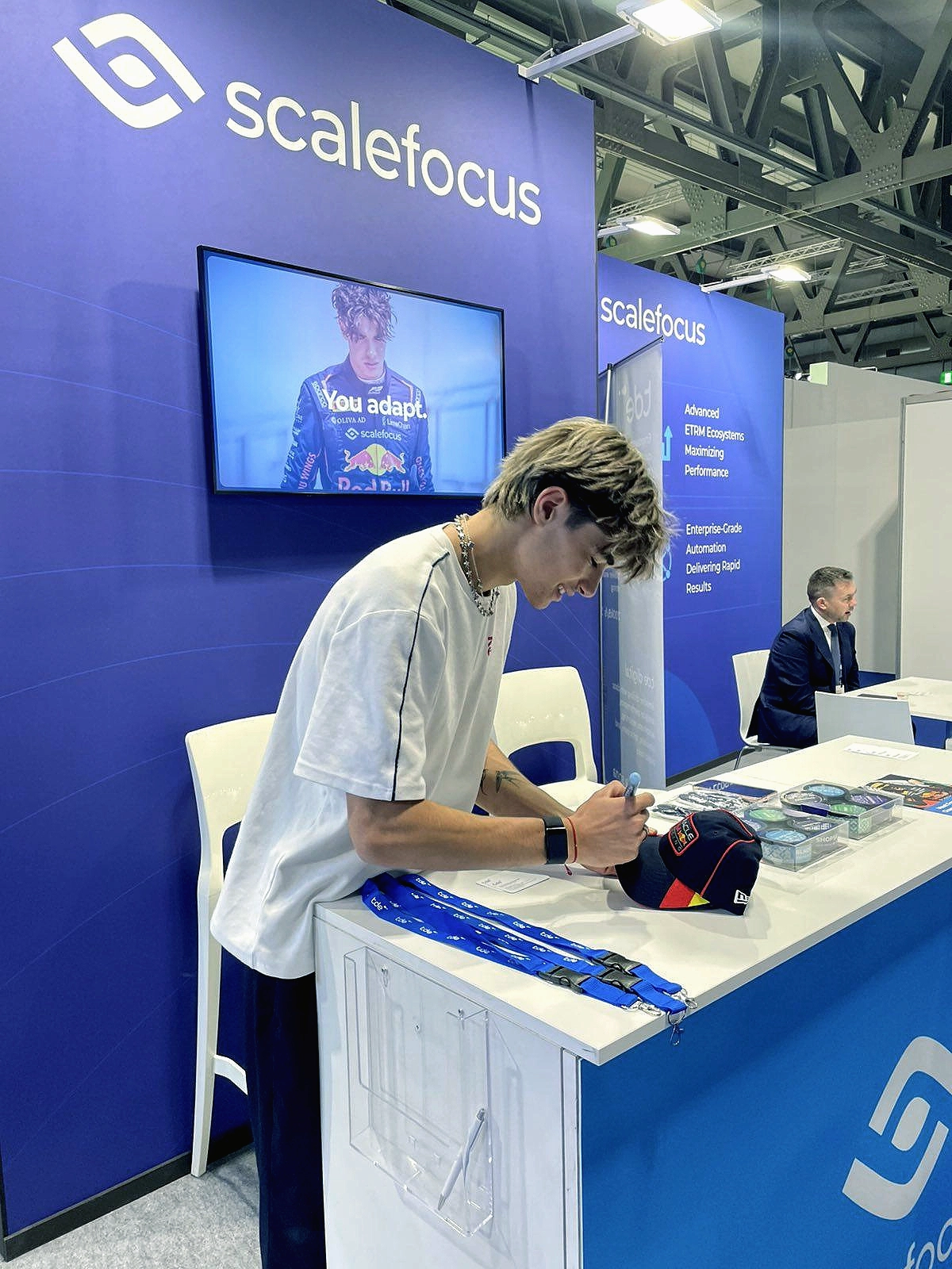 Formula 3 Vice Champion Nikola Tsolov signing a Red Bull cap at the Scalefocus booth during Gastech 2025 in Milan. 